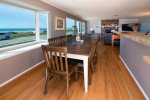 Wall to wall windows in the living room, dining room, and kitchen offer panormic ocean views